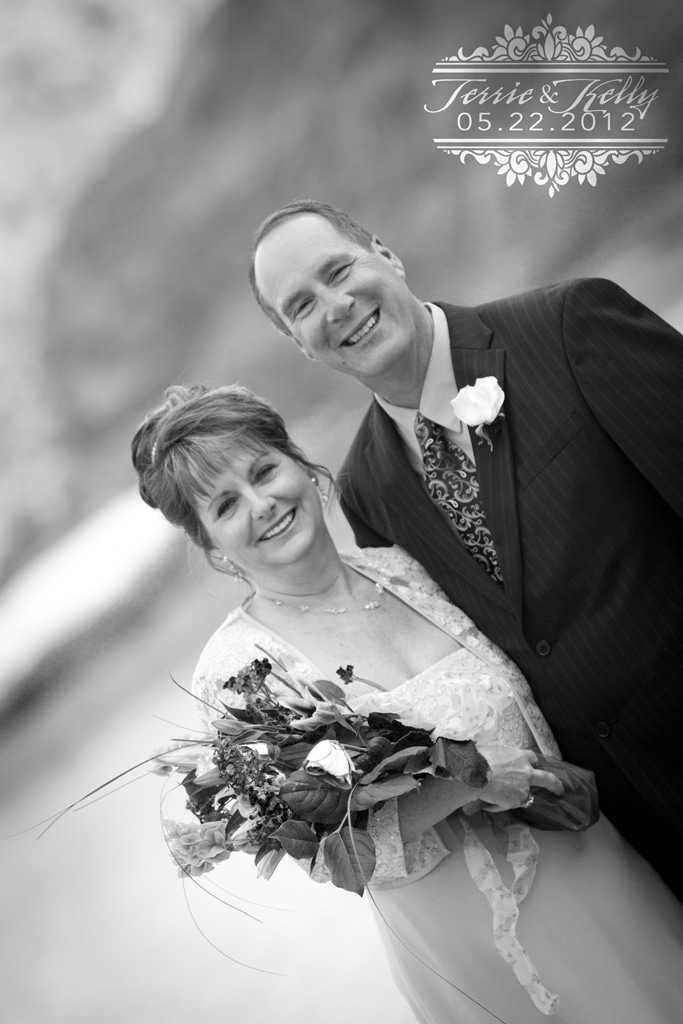 Black and white portrait of a bride and groom with a small custom watermark in the corner.
