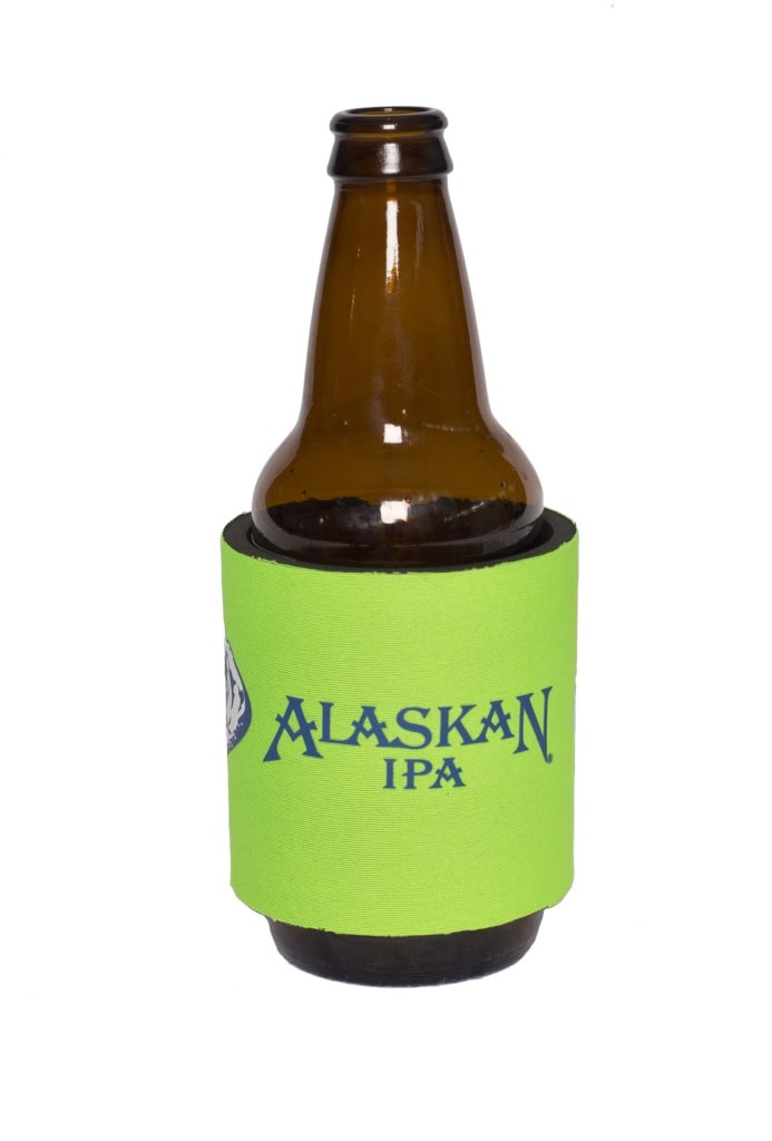 Lime green foam bottle cooler printed with Alaskan IPA, fitted around an amber glass bottle on white.