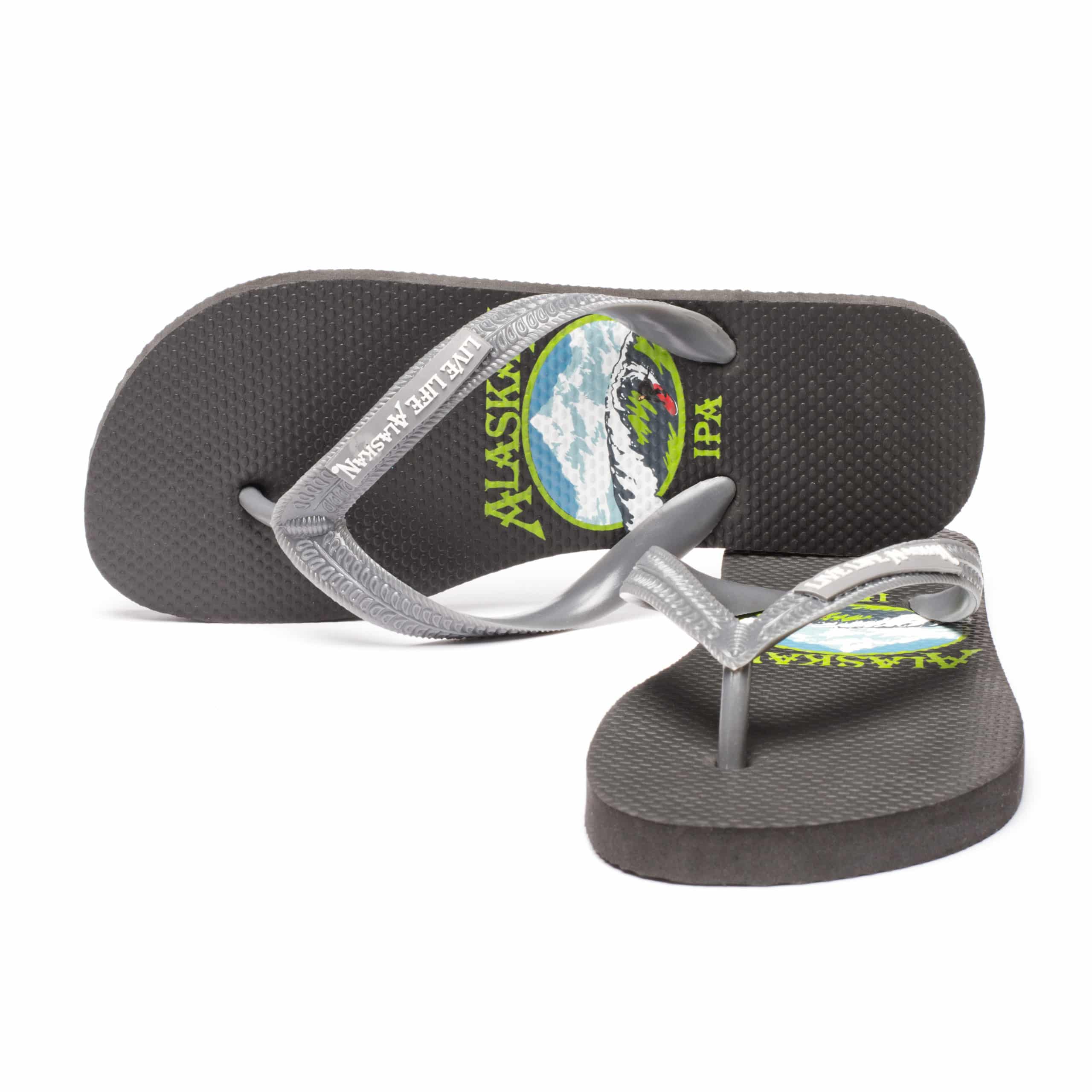 Comfortable black and gray flip flops with Alaska logo, perfect for beach or casual wear.