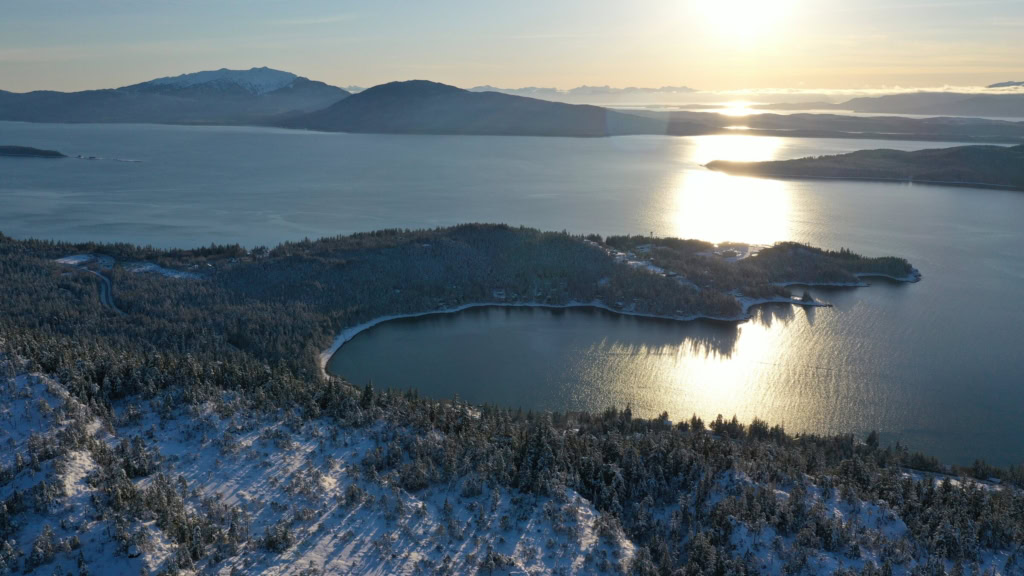 Sunset over Auke Bay with snowy forest below