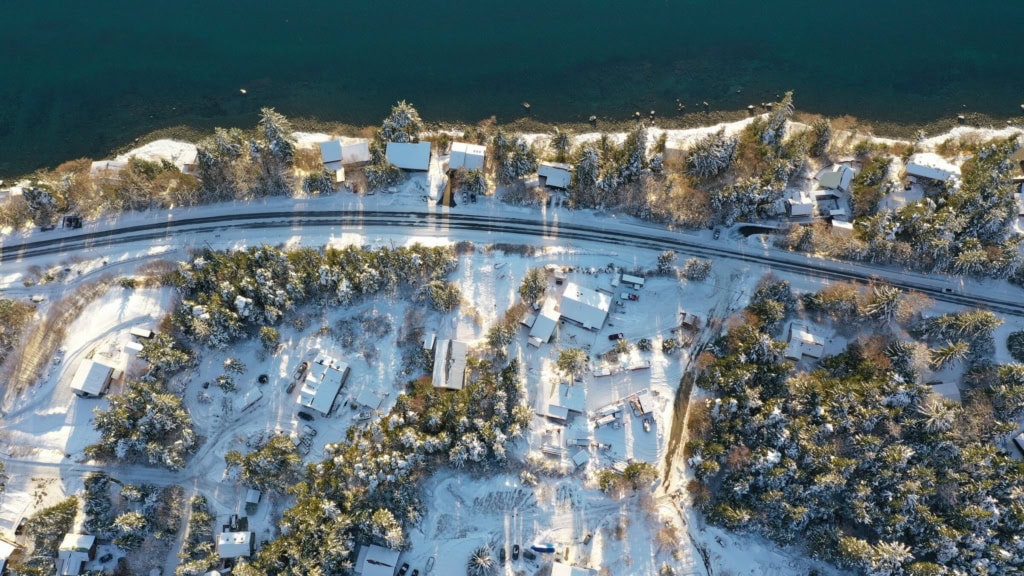 Overhead view of a snowy neighborhood beside the water