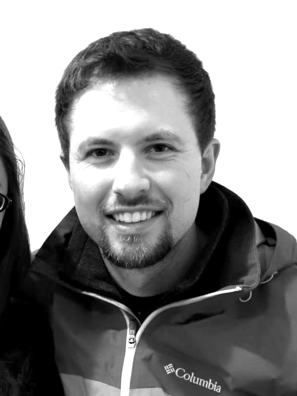 Smiling man wearing Columbia jacket, casual style, friendly expression, black-and-white photo.