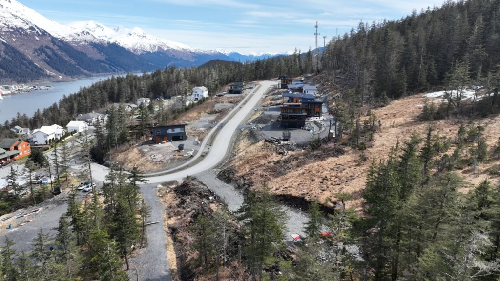 Winding road down a hillside toward houses and water