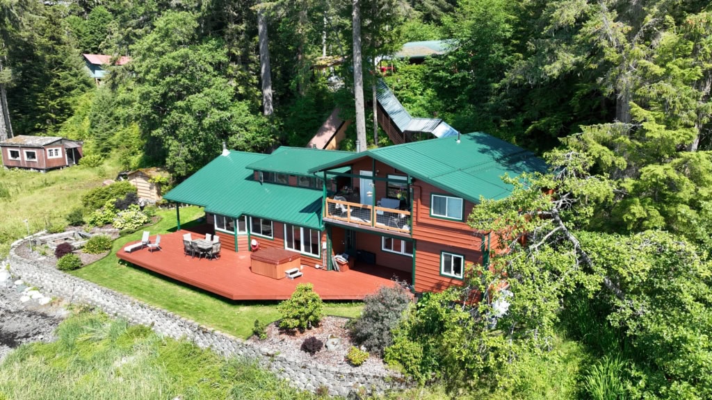 House with stone chimney, red deck and gardens
