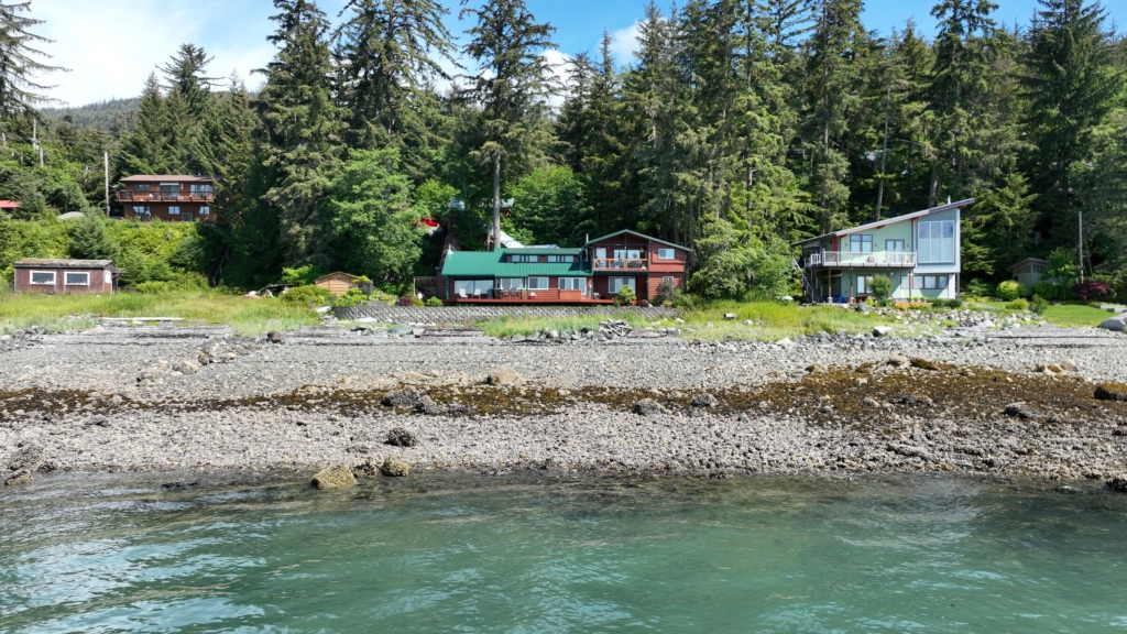 Houses along a rocky beach seen from the water