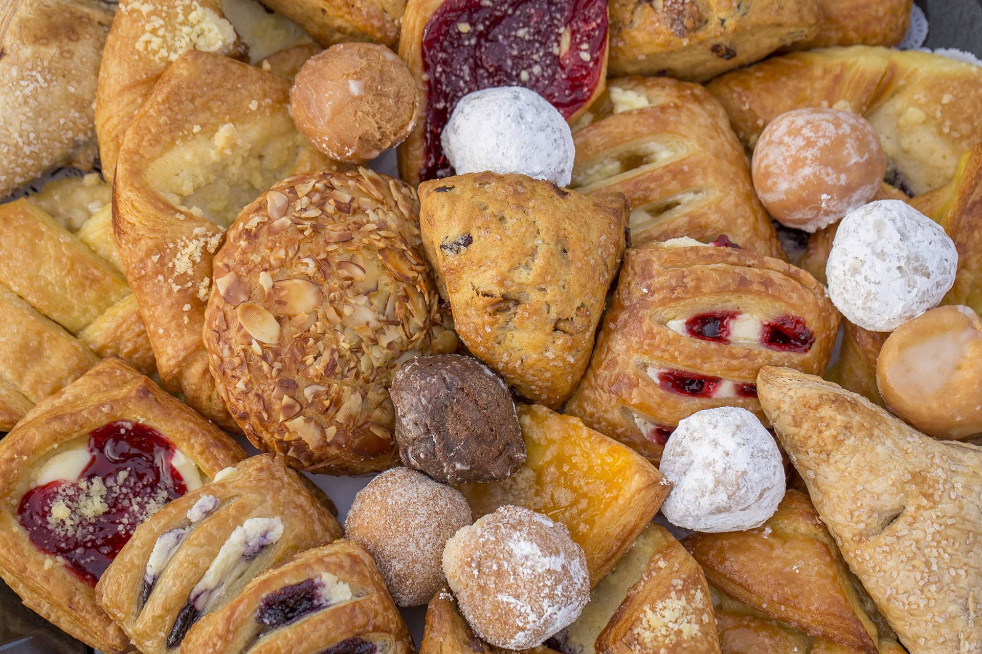 Delicious baked goods including croissants, Danish, cookies, and muffins perfect for breakfast or snacks.