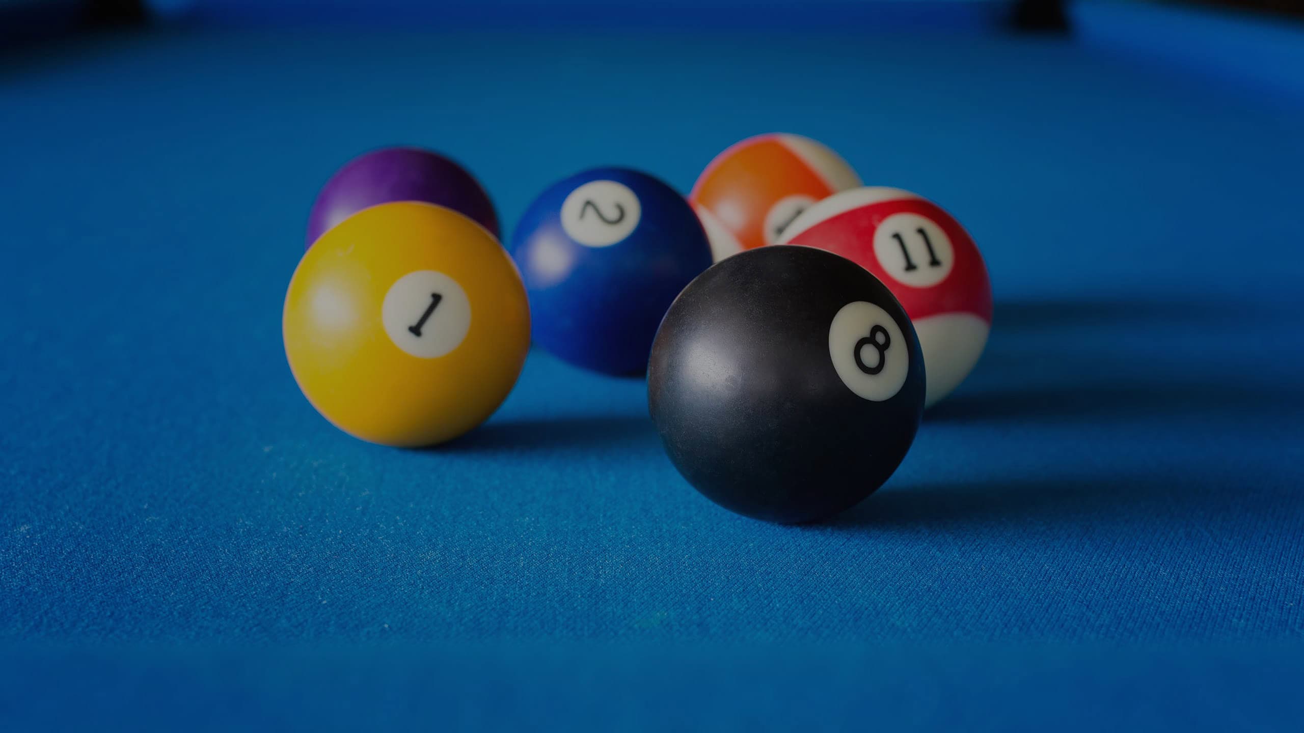 Vibrant billiard balls with numbers arranged on a blue pool table for recreational play.