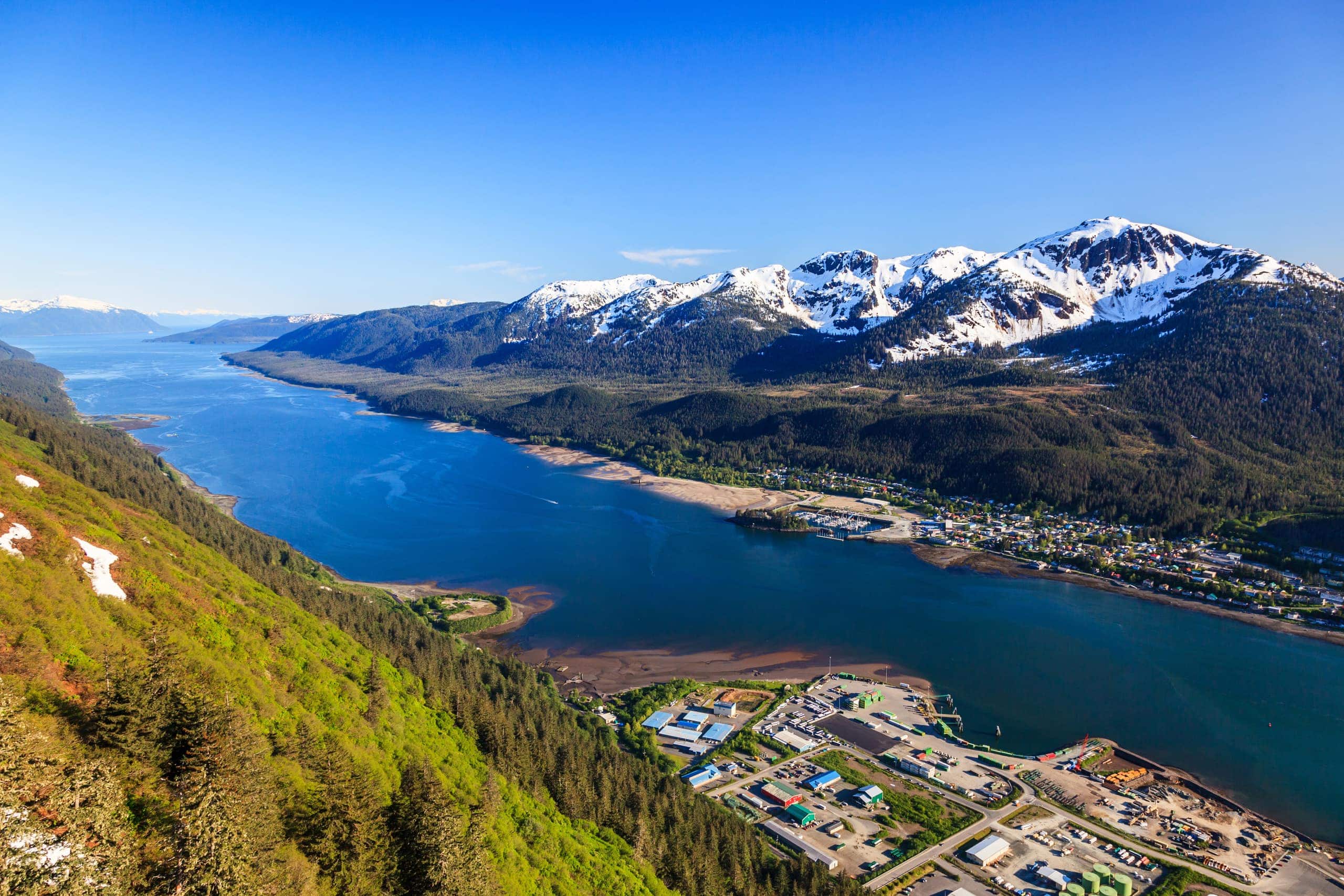 Stunning mountain and lake landscape in Oregon with snow-capped peaks and lush green forests.