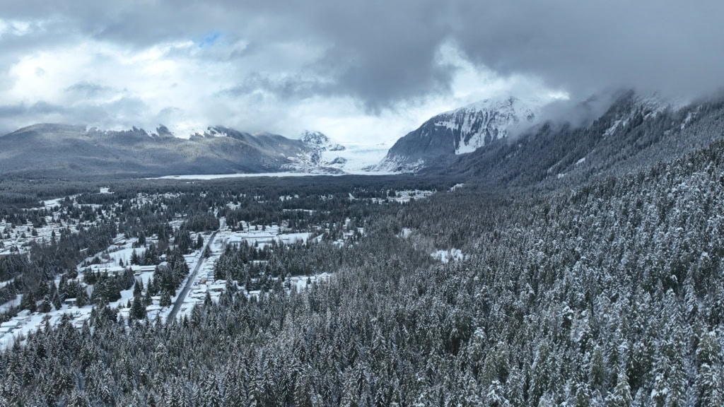 Mendenhall Glacier under breaking storm clouds above a snowy valley