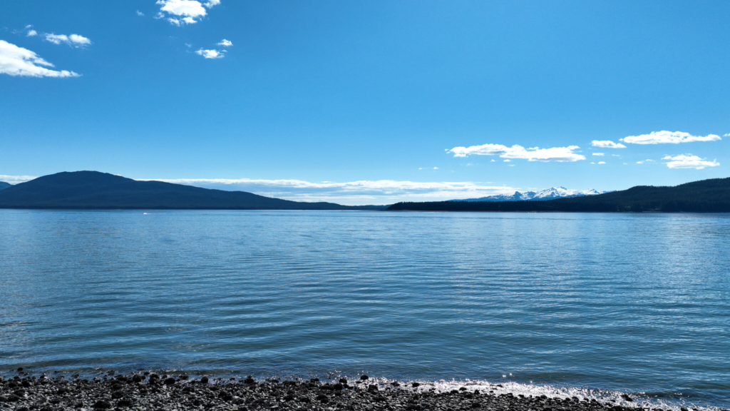 Calm water and mountains seen from a rocky beach