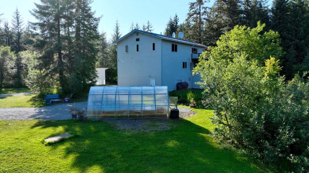House with a greenhouse and green lawn